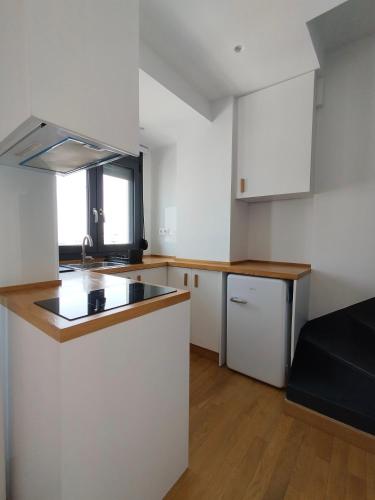 a kitchen with white cabinets and a counter top at Marelia Urban in Thessaloniki