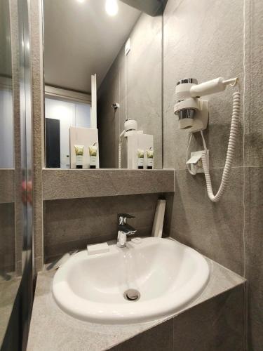 a bathroom with a white sink and a mirror at Marelia Urban in Thessaloniki