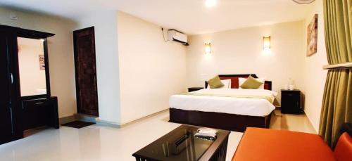 a hotel room with a bed and a couch at Wayanad Kuruva Isles Jungle Resort in Chekadi