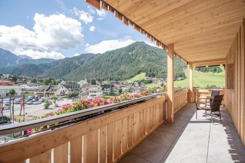 a balcony with a view of a town and mountains at Hotel Condor in San Vigilio Di Marebbe