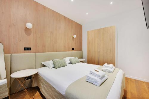 une chambre avec un lit avec des serviettes dessus dans l'établissement Charming apartment with terrasse - 1BDR- 6P - Sacré-Cœur, à Paris