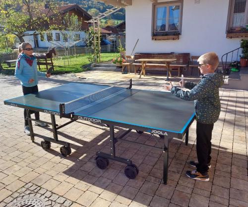 two children playing ping pong on a ping pong table at Ferien by Wallners in Bad Feilnbach