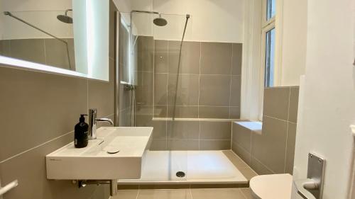 a bathroom with a shower and a sink and a toilet at STACEY Downtown in Hamburg