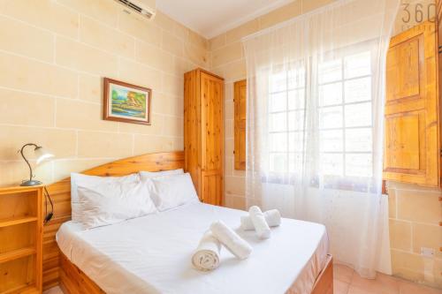 a bedroom with a bed with towels on it at Lovely Home with Private Terrace in Zebbug, Gozo by 360 Estates in Żebbuġ