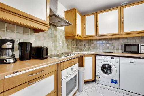 une cuisine avec un lave-linge et un sèche-linge sur un comptoir dans l'établissement Chic studio with terrace in Paris, à Paris