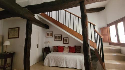 a bedroom with a bed and a staircase at La Casuca de La Vera in Valverde de la Vera