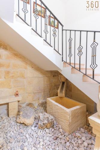 a staircase with a wooden box under a stair case at Lovely Home with Private Terrace in Zebbug, Gozo by 360 Estates in Żebbuġ