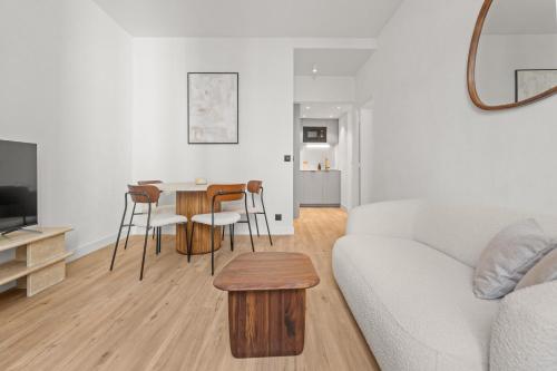 un salon avec un canapé blanc et une table dans l'établissement LB Vacation Rentals I Renovated Apartment Min from Beach and Palais, à Cannes