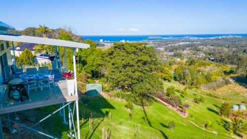an aerial view of a house with blue chairs and the ocean at Altitude - Pet-Friendly, Romantic, Accessible in Coffs Harbour