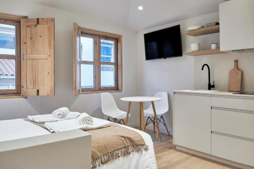 a bedroom with a bed and a kitchen with a table at Casa Beltane in A Coruña