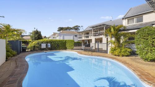 a swimming pool in front of a house at Azure - Luxe, Pool Beachfront in Kororo Basin