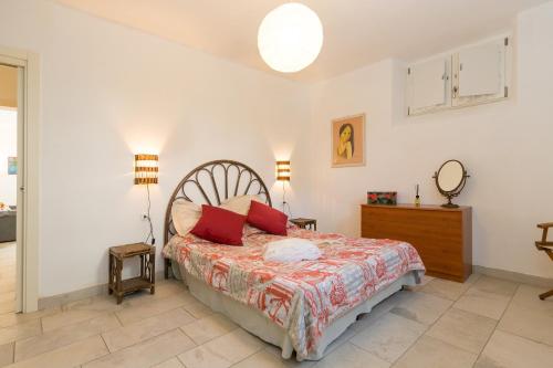 ein Schlafzimmer mit einem Bett mit roten Kissen in der Unterkunft Villa Corallo Sofia in San Vincenzo