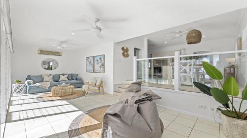 un soggiorno con un divano e un tavolo di Fairways Beach House - Pool, Golf, Sawtell Village, Family Friendly a Sawtell