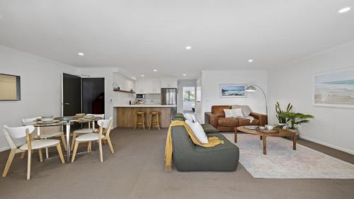 a living room with a couch and a table at Figtree on First - Heart of Sawtell Village, Beach, Shops in Sawtell