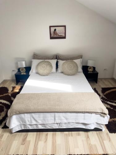 a bedroom with a large white bed with two pillows at Enjoy Apartments - Central Skylight Residence in Cluj-Napoca