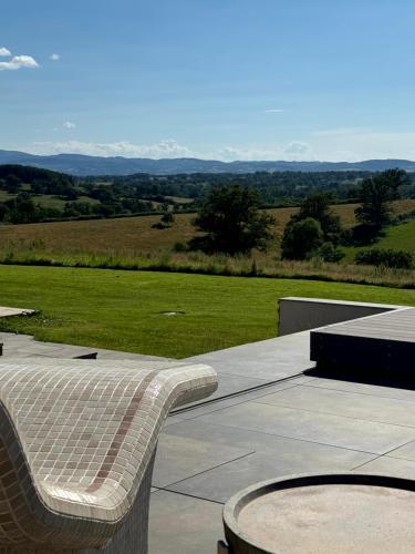 a bench sitting on a patio with a view at Le Clos Vercheron in Artaix