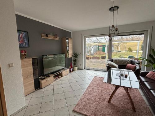 a living room with a couch and a tv at Ferienwohnung Heike in Hilbersdorf