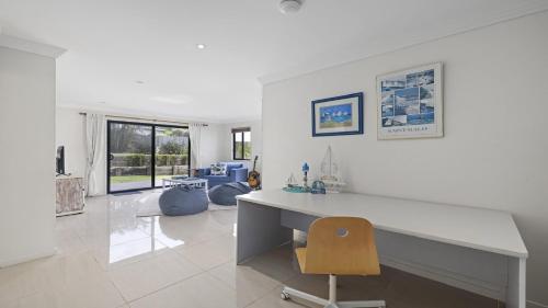a white office with a desk and a chair at Lighthouse at Emerald Beach - Ocean Views, walk to beach in Emerald Beach