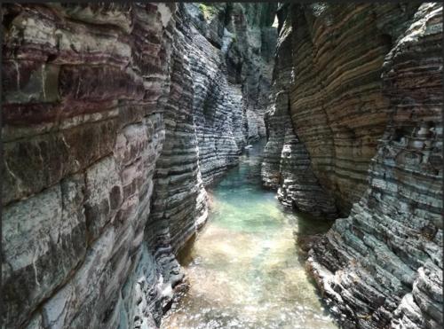 a cave with a pool of water in a canyon at Orizzonte spezzino in La Spezia