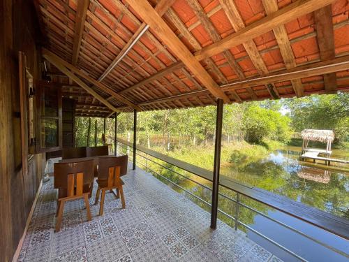 a screened porch with a desk and a view of a river at Thôn Hoa Sen in Thôn Xuân Lỗ