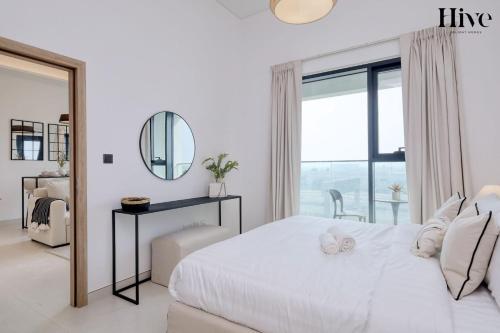 a white bedroom with a large bed and a mirror at 7 By Aurora 301 in Dubai