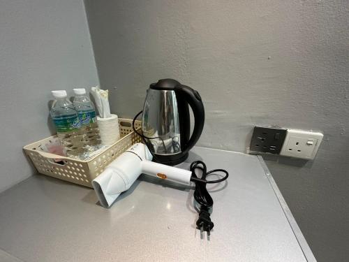 a kitchen counter with a coffee maker and a light switch at SS Grey Hotel 2 in Kuala Lumpur