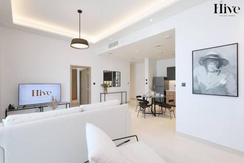 a living room with white furniture and a dining room at 7 By Aurora 310 in Dubai