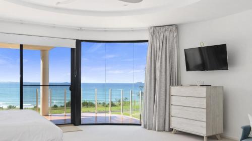 a bedroom with a view of the ocean at Villa Provence - Stunning Views, Walk to resorts. 5 Bed 3 Bath in Coffs Harbour