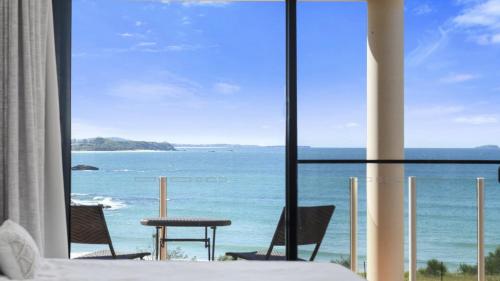 a bedroom with a view of the ocean from a window at Villa Provence - Stunning Views, Walk to resorts. 5 Bed 3 Bath in Coffs Harbour