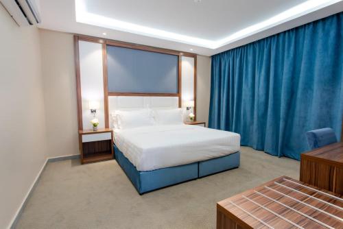 a bedroom with a bed and a large window at منتجع حياة ريزيدنس in Abha
