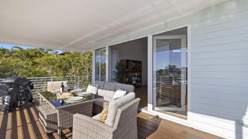 a patio with chairs and a table and a grill at Tea Trees - Modern Townhouse, Village and Beach in Woolgoolga