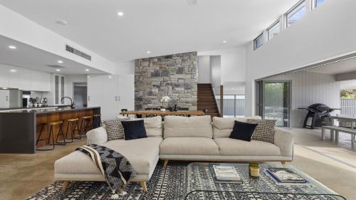 a living room with a couch and a kitchen at Serendipity - Pool, Pets OK, Fireplace, Village Location in Sawtell