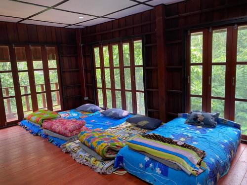 a bedroom with two beds in a room with windows at MAE-TON LUANG Camping in Ban Pang Haen