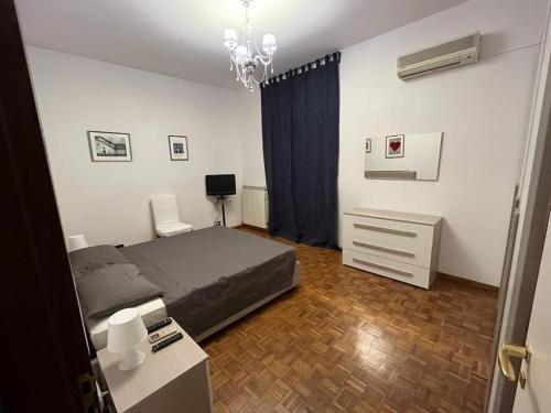 Un dormitorio con una cama, un escritorio y una lámpara de araña. en MiCasa Sullo Jonio, en Taranto