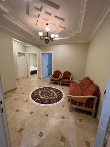 - un salon avec deux chaises et un tapis dans l'établissement شقة فاخرة مدخل ذاتي, à Buraydah