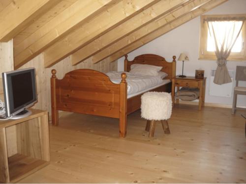 a bedroom with a bed and a desk with a television at Itrognon, douillet et cosy! in Zinal