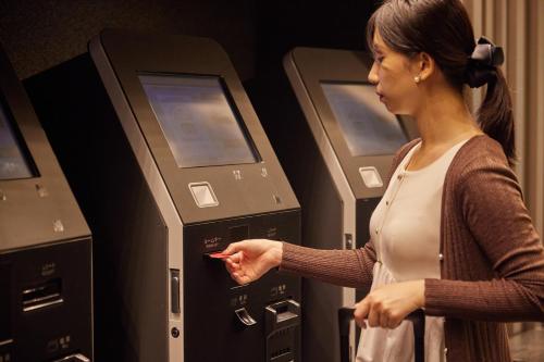 a woman standing in front of four atm machines at Kobe Motomachi Tokyu REI Hotel in Kobe
