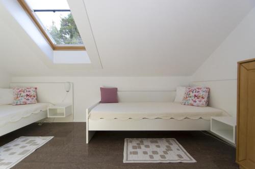 Cette chambre dispose d'un canapé blanc et d'une fenêtre. dans l'établissement Apartments Villa Olea, à Lumbarda