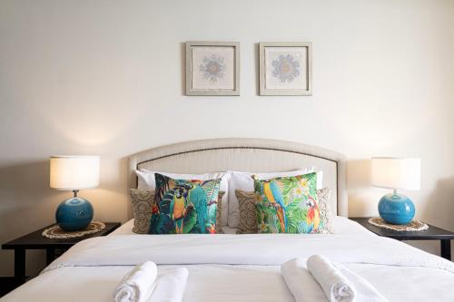 a bedroom with a white bed with two lamps at Luxury Apartments in Anantara Resort with Stunning Burj AlArab & Sea Views in Dubai