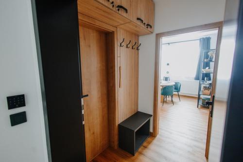 a hallway with a door and a room with a table at U Boží lišky by Mountain ways in Boží Dar