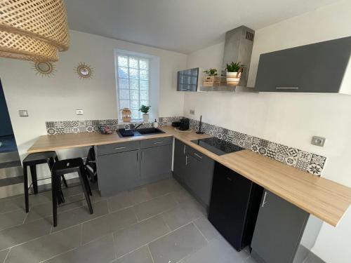 a kitchen with a counter and a table in it at Chez Mely, le petit nid bombonnais in Bombon