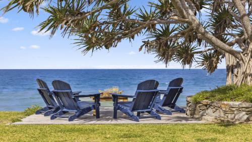 a group of chairs and a table on the beach at Hampton on the Beach - Stunning Beach Front, Sleeps 8 in Sapphire Beach