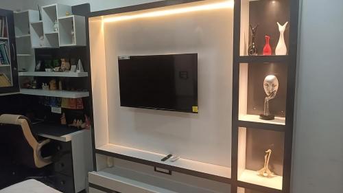 a entertainment center with a flat screen tv on a wall at The Great Escape - Rustic Countryside Stay in Amritsar