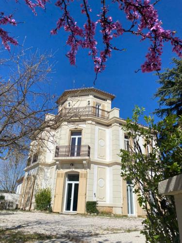 a building with a balcony on top of it at Mes nuits au château au domaine du pressoir in Pierrefeu-du-Var