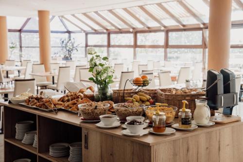 a buffet with bread and other foods on a table at Rodinný Hotel Hubert High Tatras in Vysoké Tatry