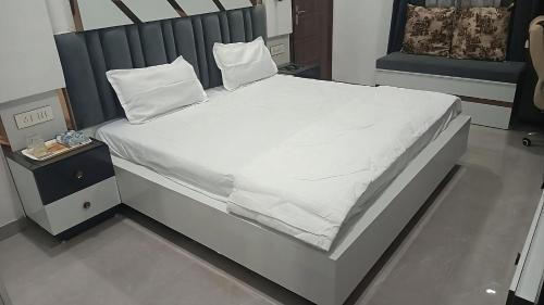 a bed with white sheets and pillows on it at The Great Escape - Rustic Countryside Stay in Amritsar