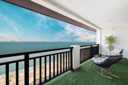 a balcony with a view of the ocean at Luxury Apartments in Anantara Resort with Stunning Burj AlArab & Sea Views in Dubai