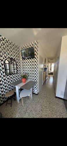 une salle à manger avec une table et un mur dans l'établissement T2 moderne à 2 min de la plage, à Port-la-Nouvelle