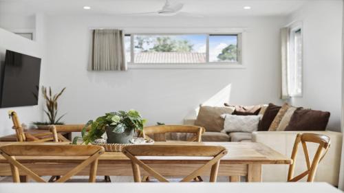 a living room with a wooden table and chairs at Seas the Day - Modern Townhouse in Sawtell Village in Sawtell