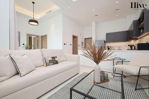 a white living room with a white couch and a table at 7 By Aurora 102 Jebel Ali in Dubai